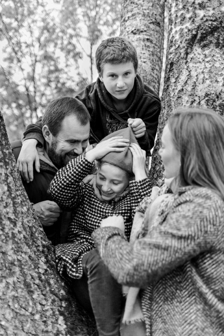 Portrait de famille en noir et blanc dans un arbre, en extérieur.
