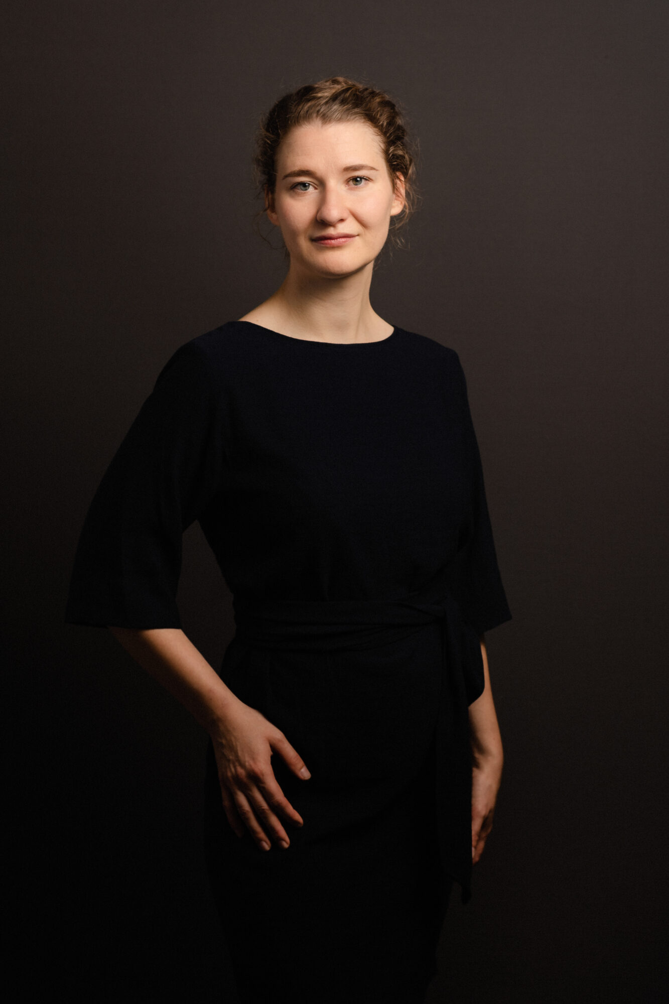 Portrait professionnel d'un femme en robe posant devant un fond marron